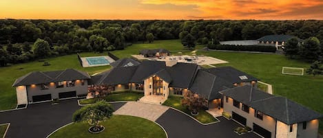 A large estate with multiple buildings, a well-maintained lawn, and a golf course.