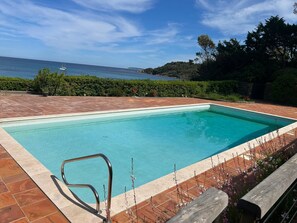 A rectangular swimming pool with a metal ladder, surrounded by a tiled patio. - Beachfront Home (Bormes-les-Mimosas)