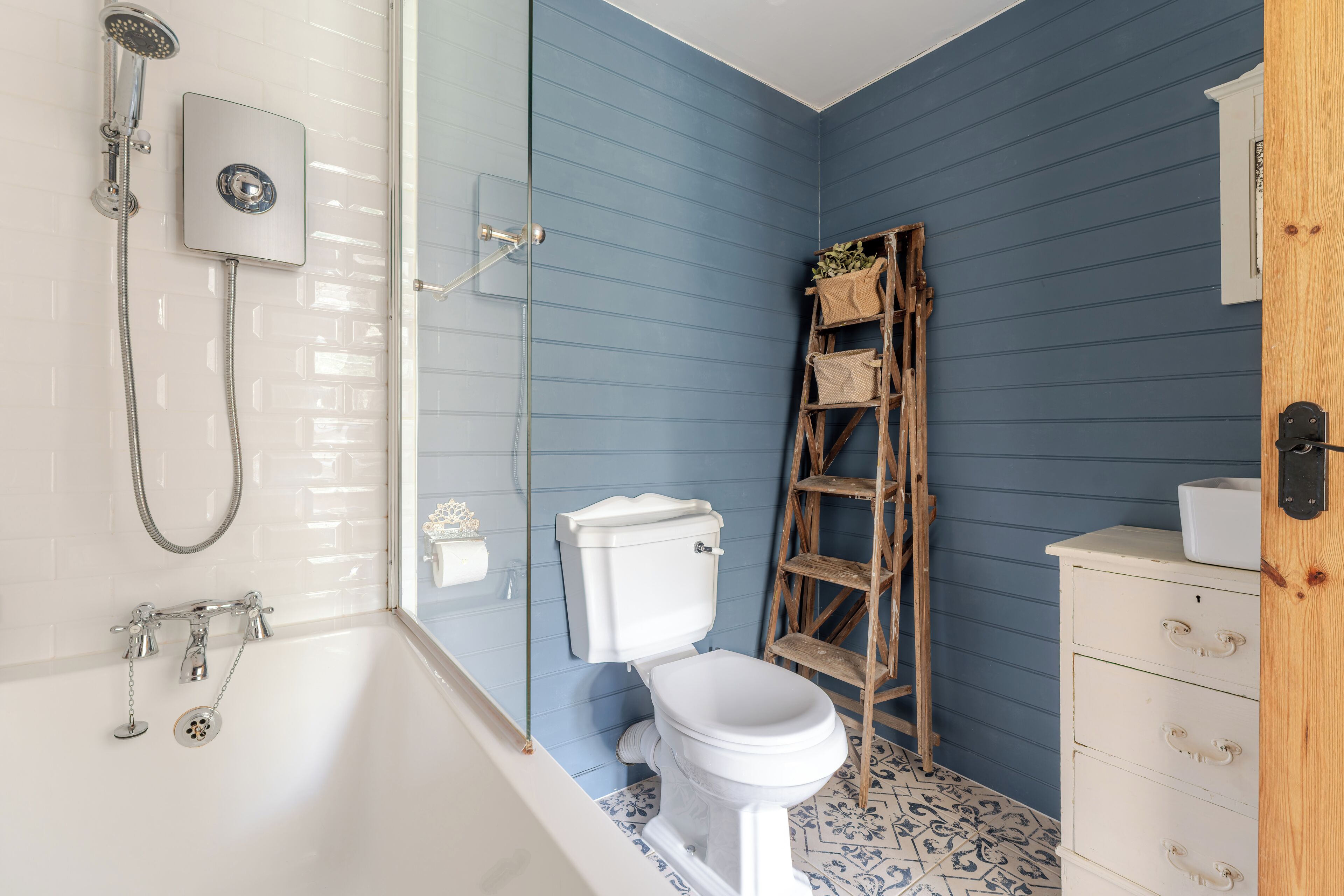 Un baño con una bañera blanca, un inodoro y una ducha.