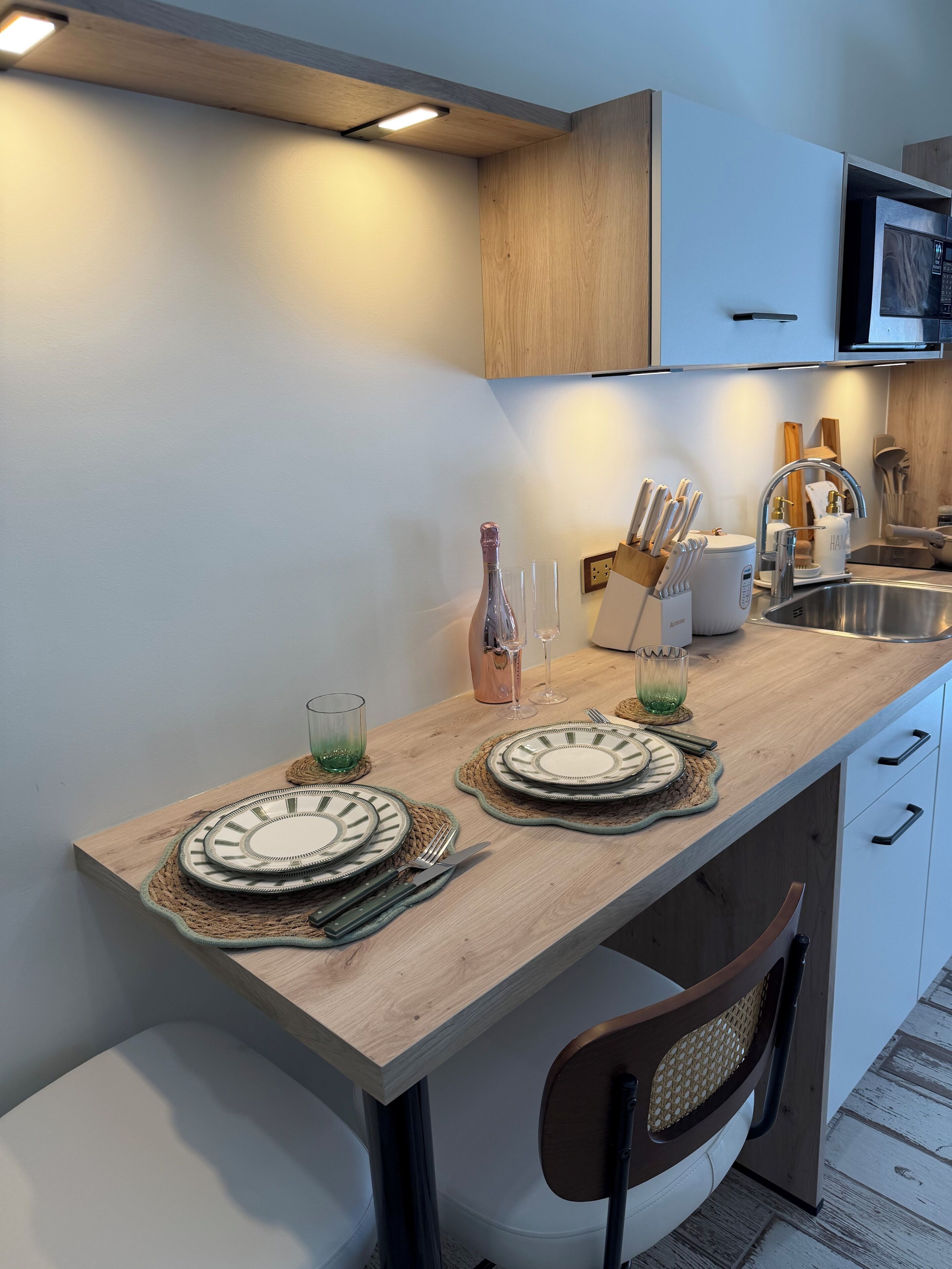 A modern kitchen with wooden countertops, a built-in microwave, and a sink.