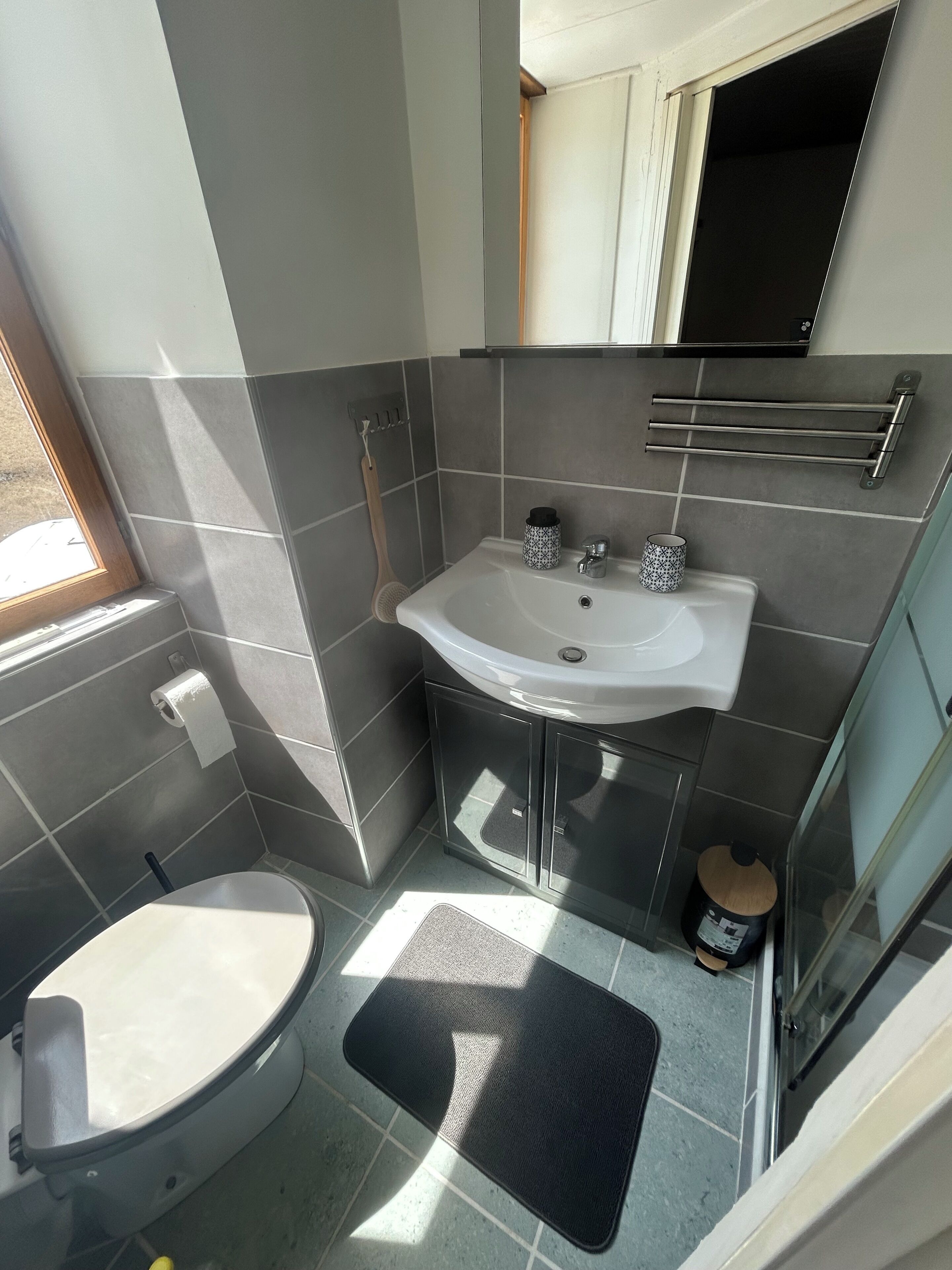 A bathroom with a toilet, sink, and shower.