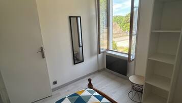 Una camera da letto con un letto, una finestra, uno specchio e un armadio.