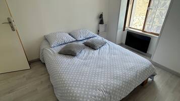 Une chambre à coucher avec un lit, une lampe de chevet et une fenêtre donnant sur un beau paysage.