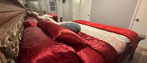 A bedroom with a large bed, a wardrobe, and a mirror.