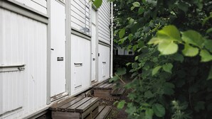 A white building with a wooden staircase leading to a door.