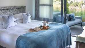 Un dormitorio con una cama grande, un sofá y vistas al exterior.