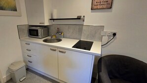 Una kitchenette compacta con microondas, pileta y cocina.