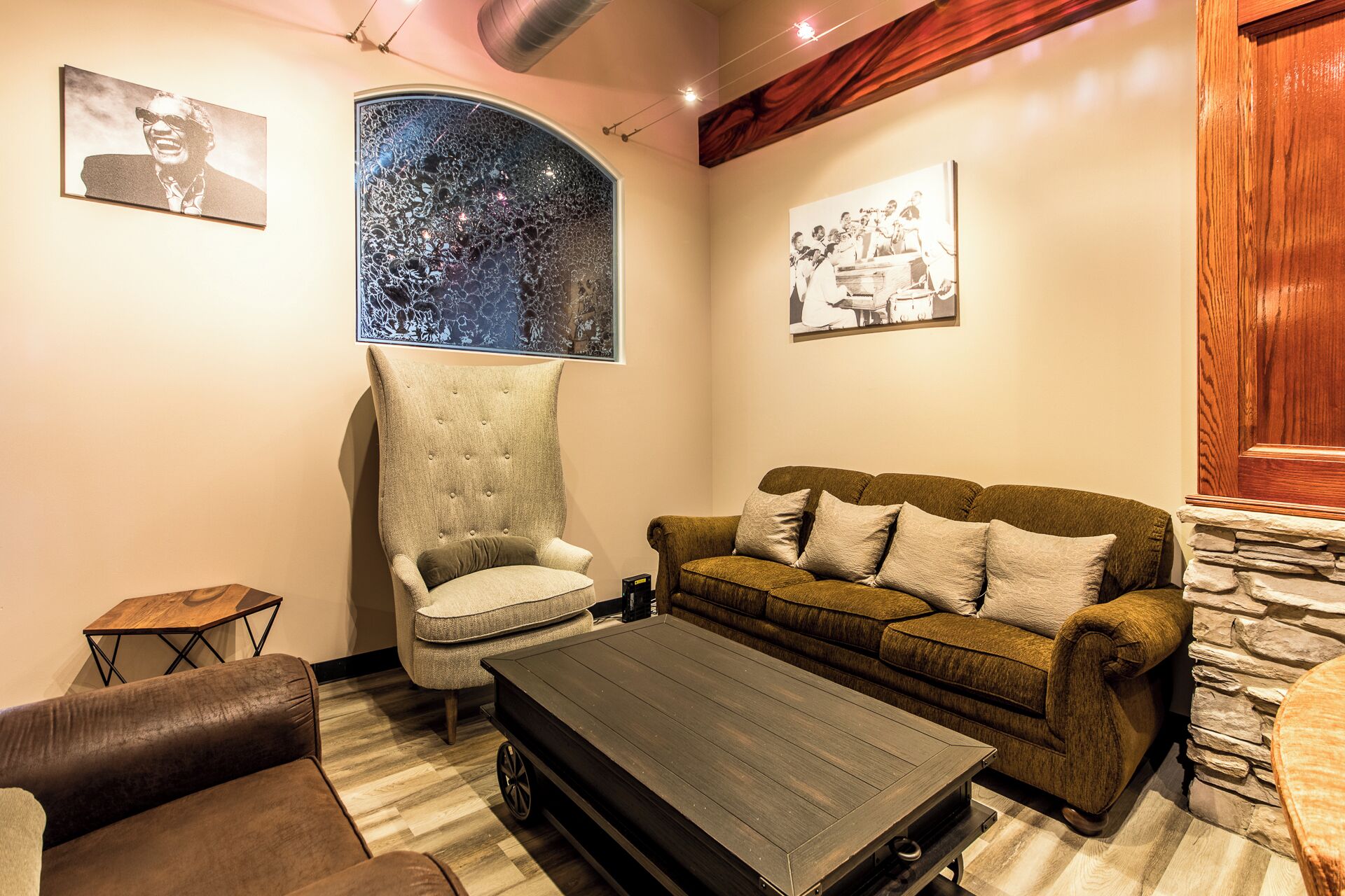 A living room with a high-backed armchair, a sofa, a coffee table, and a small side table.