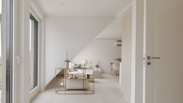 A modern, minimalist interior with a central console table, a white door, and a view through a large window. - lux Rooftop with A/C - Schönbrunn & Central Vienna (Wien)