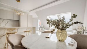 A modern dining area with a marble table, chairs, and a vase of flowers. - lux Rooftop with A/C - Schönbrunn & Central Vienna (Wien)