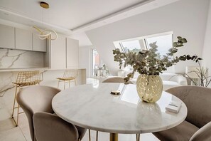 A modern dining area with a marble table, chairs, and a vase of flowers. - lux Rooftop with A/C - Schönbrunn & Central Vienna (Wien)