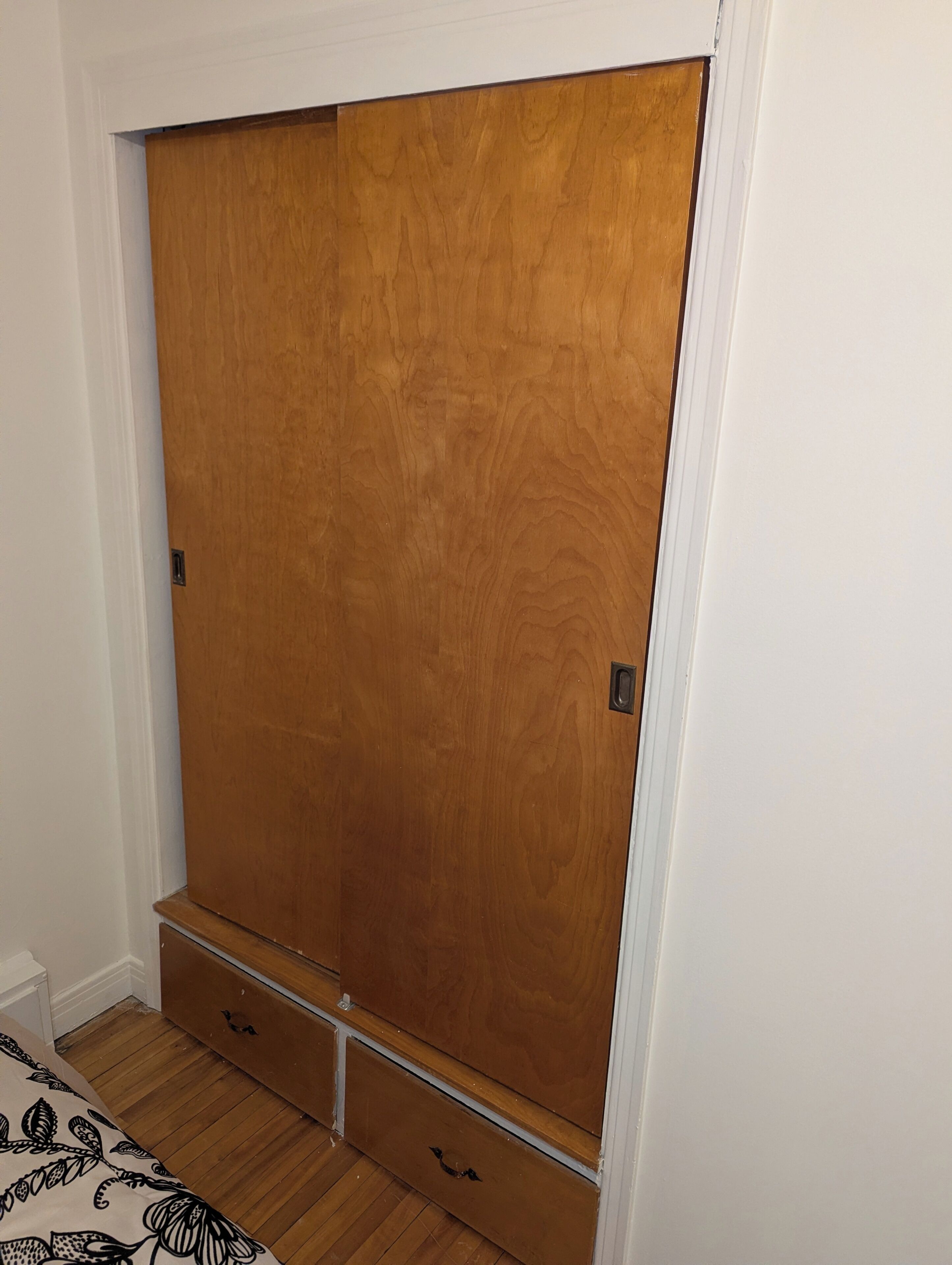 Un armario de madera con dos cajones y espacio para colgar.