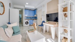 A modern apartment with a kitchen, dining area, and living room. - LXR Esmeralda 2-Bedroom Near the Ocean (Fuengirola)