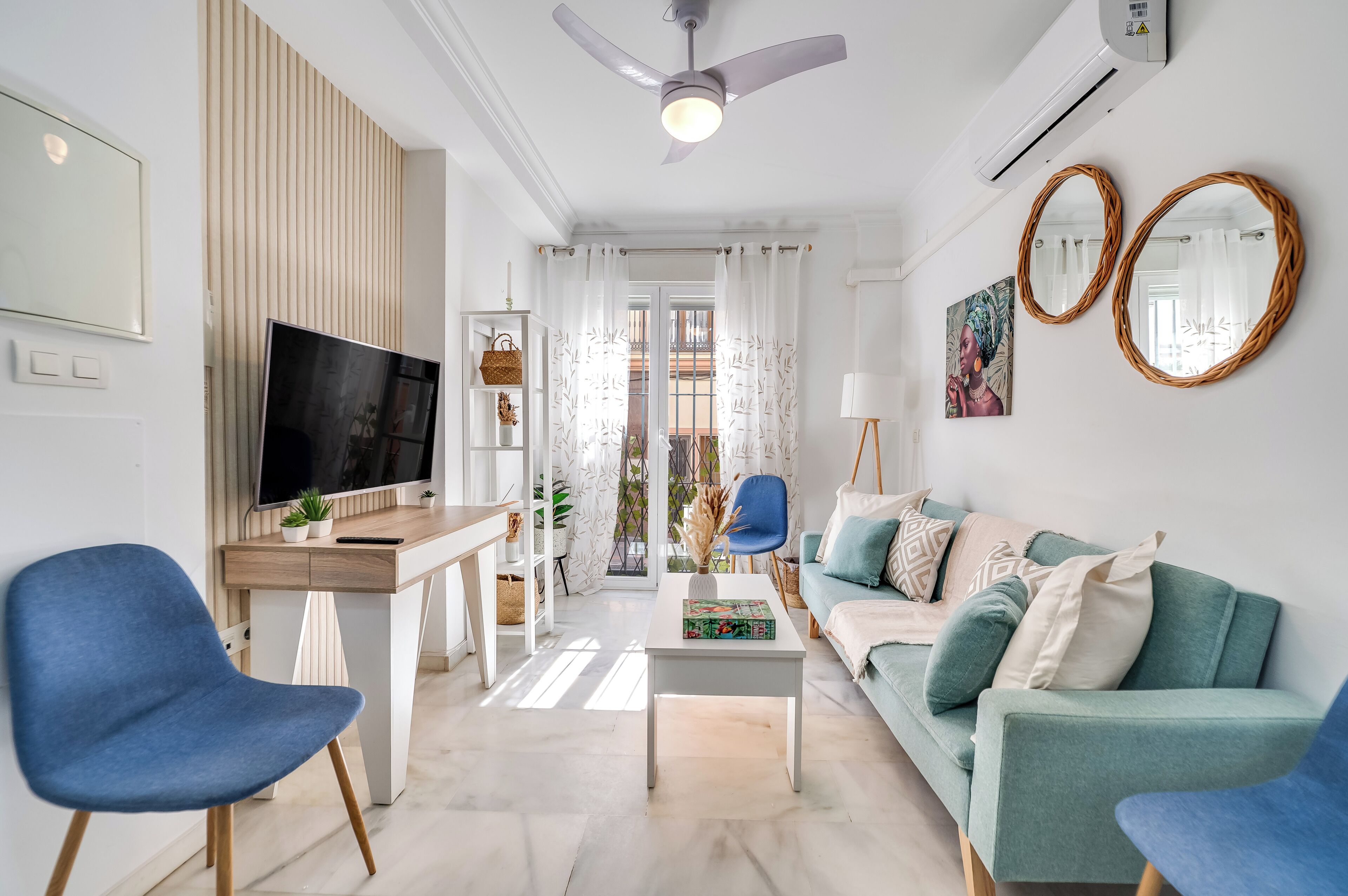 A modern living room with a TV, sofa, coffee table, and chairs.