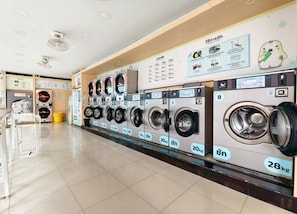A laundromat with multiple washing machines, each labeled with capacity and weight. - 208 Budget Room Wi-fi &utilities Bangkok (Bangkok)