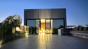 A modern building with a glass facade, a flat roof, and a paved entrance area. - Villa D'horizon (Marrakech)