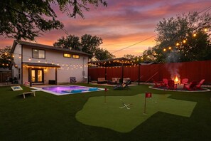 A backyard with a pool, artificial grass, a fire pit, and outdoor seating. - Sale 10/29-11/1 Heated Pool|Fire Pit|Mini Golf (Austin)