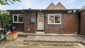 A wooden house with a front door, two windows, and a small porch area. - Studio Retreat Sleeps 1 - Wifi & Parking (Cambridge)