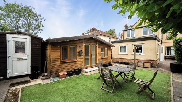 A wooden cabin with a small patio, a door, and a window. - Studio Retreat Sleeps 1 - Wifi & Parking (Cambridge)
