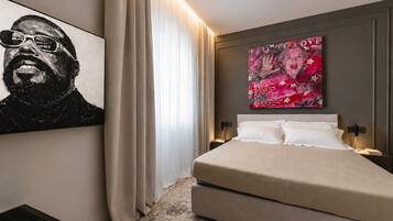 Una camera da letto moderna con un letto grande, un quadro appeso al muro e un poster.