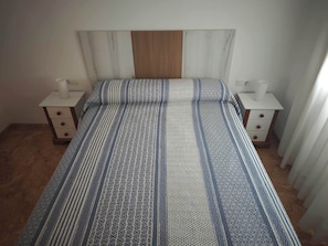 Une chambre à coucher avec un lit, deux tables de chevet et une tête de lit en bois.