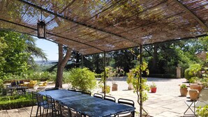 An outdoor patio with a table and chairs, surrounded by potted plants and trees. - Large villa very close to Aix-en-Provence (Aix-en-Provence)