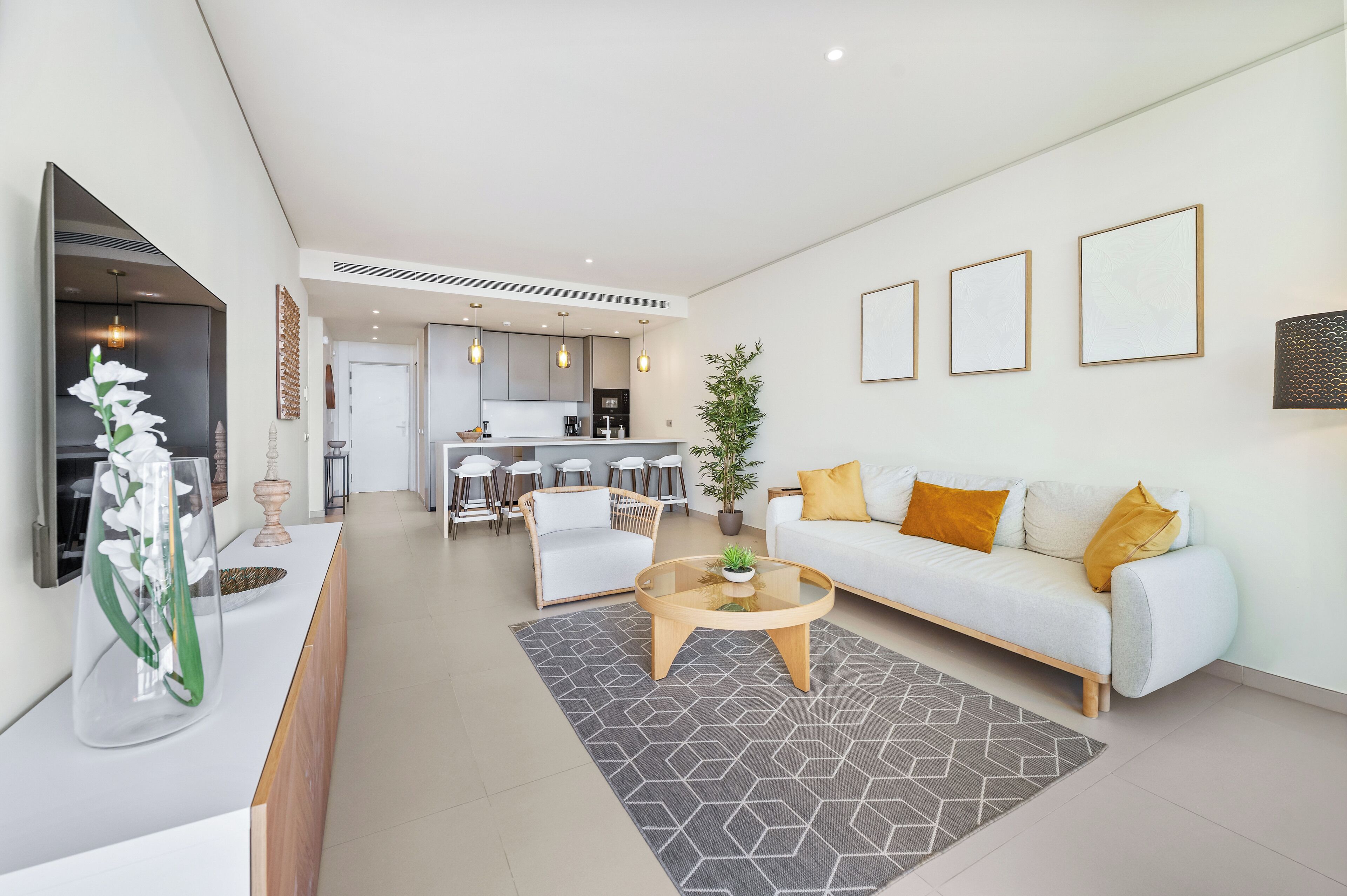 A modern living room with a sofa, coffee table, and dining area.