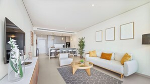 Ett modernt vardagsrum med en soffa, ett soffbord och en matplats.