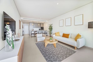 Ein modernes Wohnzimmer mit Sofa, Couchtisch und Essbereich.