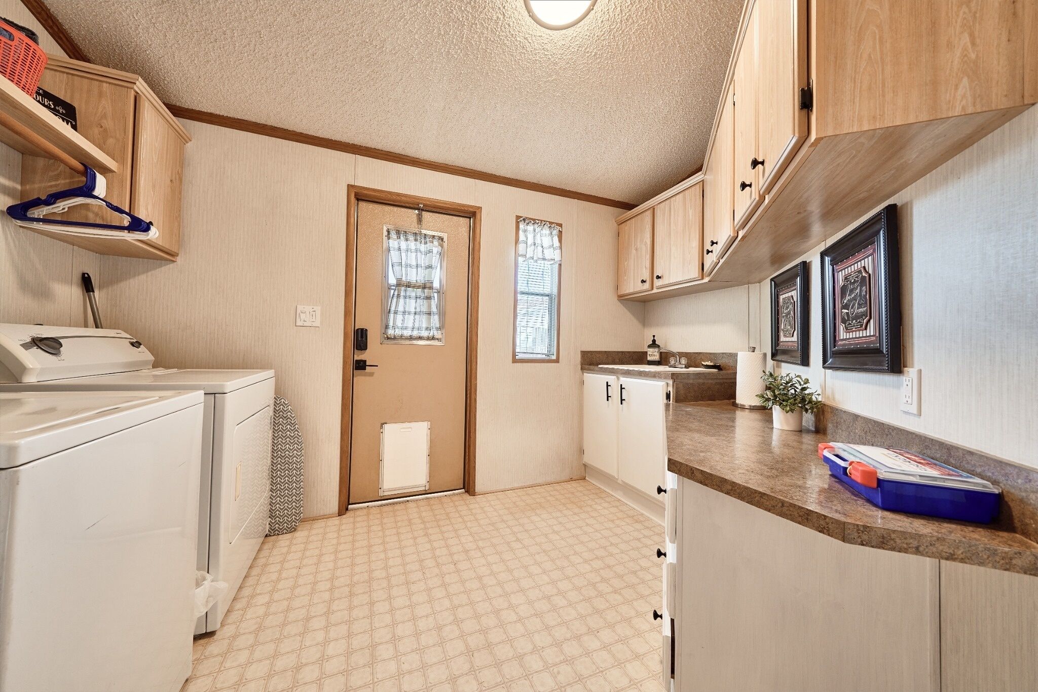 A compact kitchen with a washing machine, a sink, and a small countertop.
