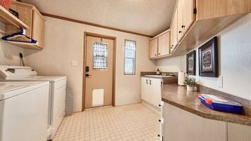 A compact kitchen with a washing machine, a sink, and a small countertop.