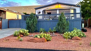 Un edificio de dos pisos con cerca azul, un patio con cactus y un letrero que indica un restaurante.