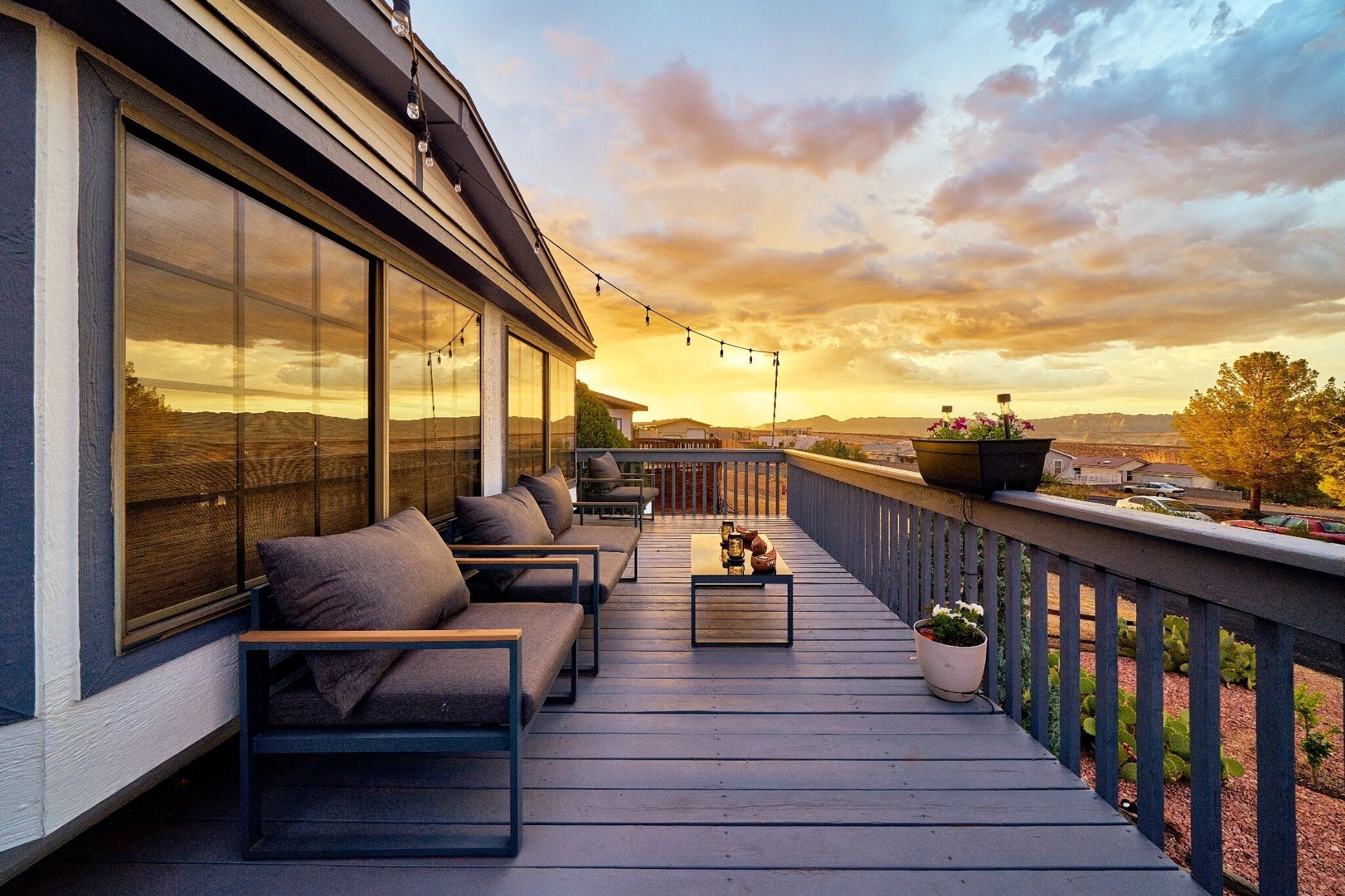 Terraza con mobiliario exterior, planta en maceta y vista al paisaje.