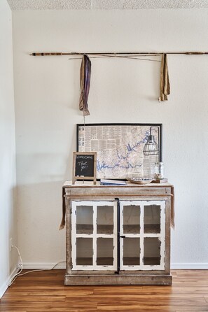 A rustic wooden cabinet with a map and a chalkboard sign against a plain wall.