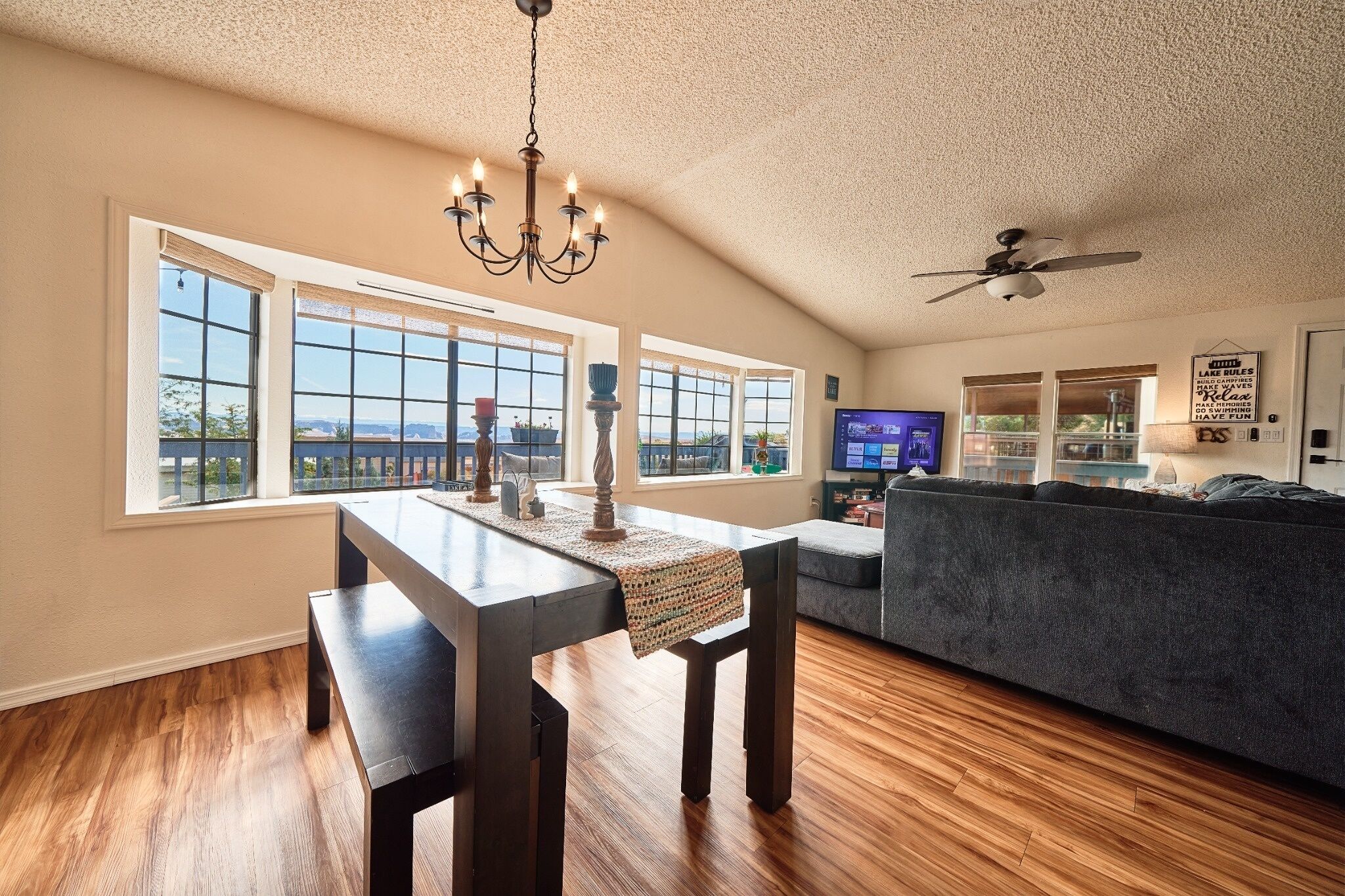 A spacious living area with a dining table, a sofa, and a television.