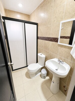 Een douche, handdoeken, zeep, toiletpapier