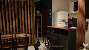 Une cuisine moderne avec un coin bar, des meubles en bois et un sol carrelé.