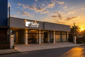 Sely Suites -niminen hotelli, jossa on moderni julkisivu, suuret ikkunat ja hyvin valaistu sisäänkäynti.