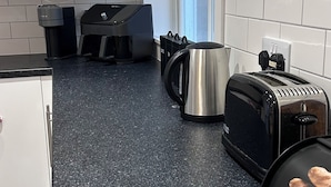 A kitchen with white cabinets, a granite countertop, a kettle, a toaster, and a coffee maker. - Sleeps 4 • City Centre Gem • Private Rooftop Feel Terrace • Great for Groups (Kingston upon Hull)