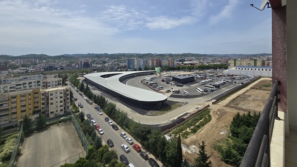 Une vue d’une ville avec un grand carrefour giratoire, des immeubles et un parking.