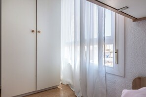 A room with a sliding door, a window with curtains, a wooden floor, and a white textured wall. - LXR Vistahermossa 3-Bedroom Very close to the sea (Fuengirola)