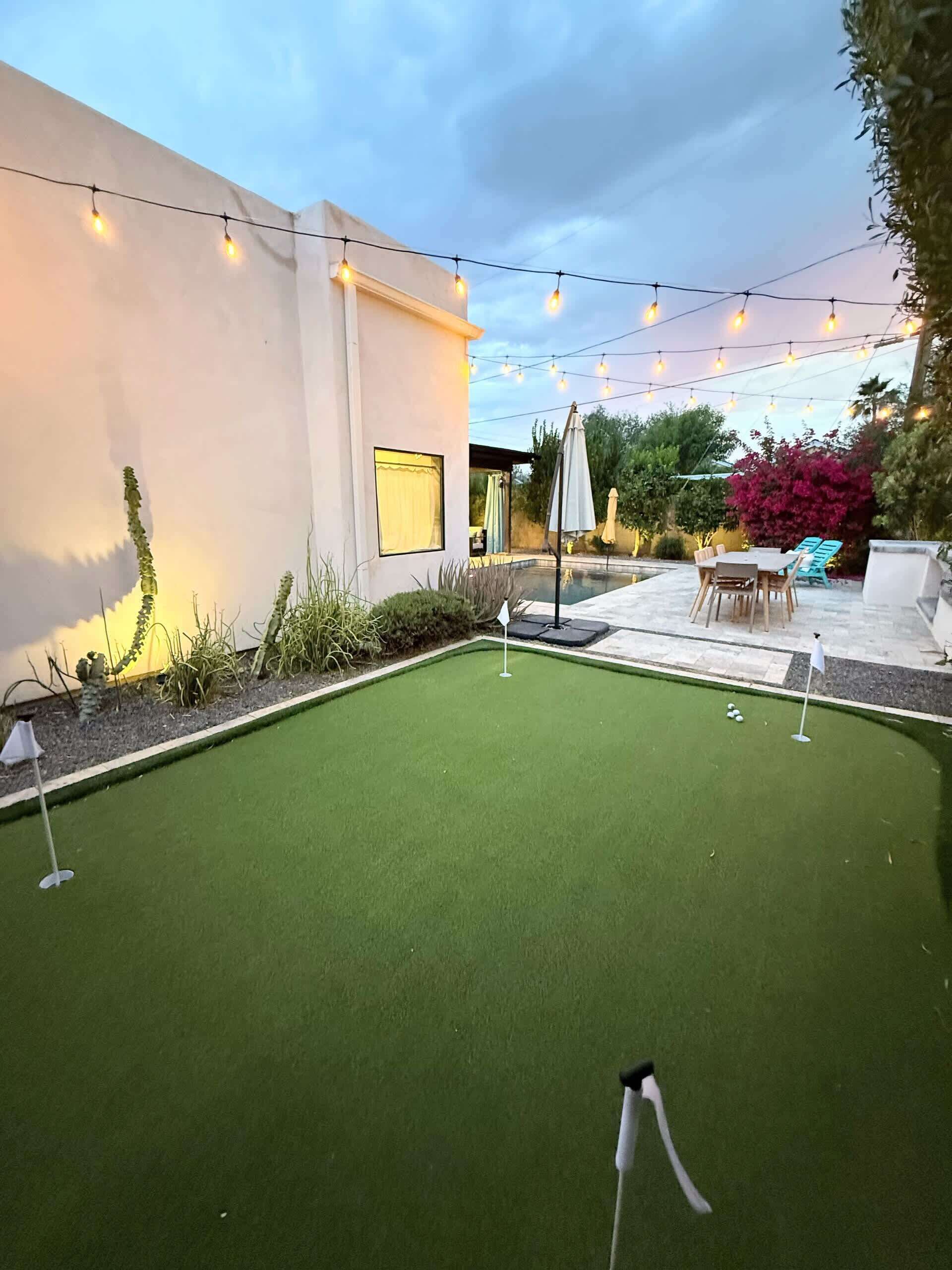 A mini-golf setup with artificial turf, a putting green, and a flagstick.