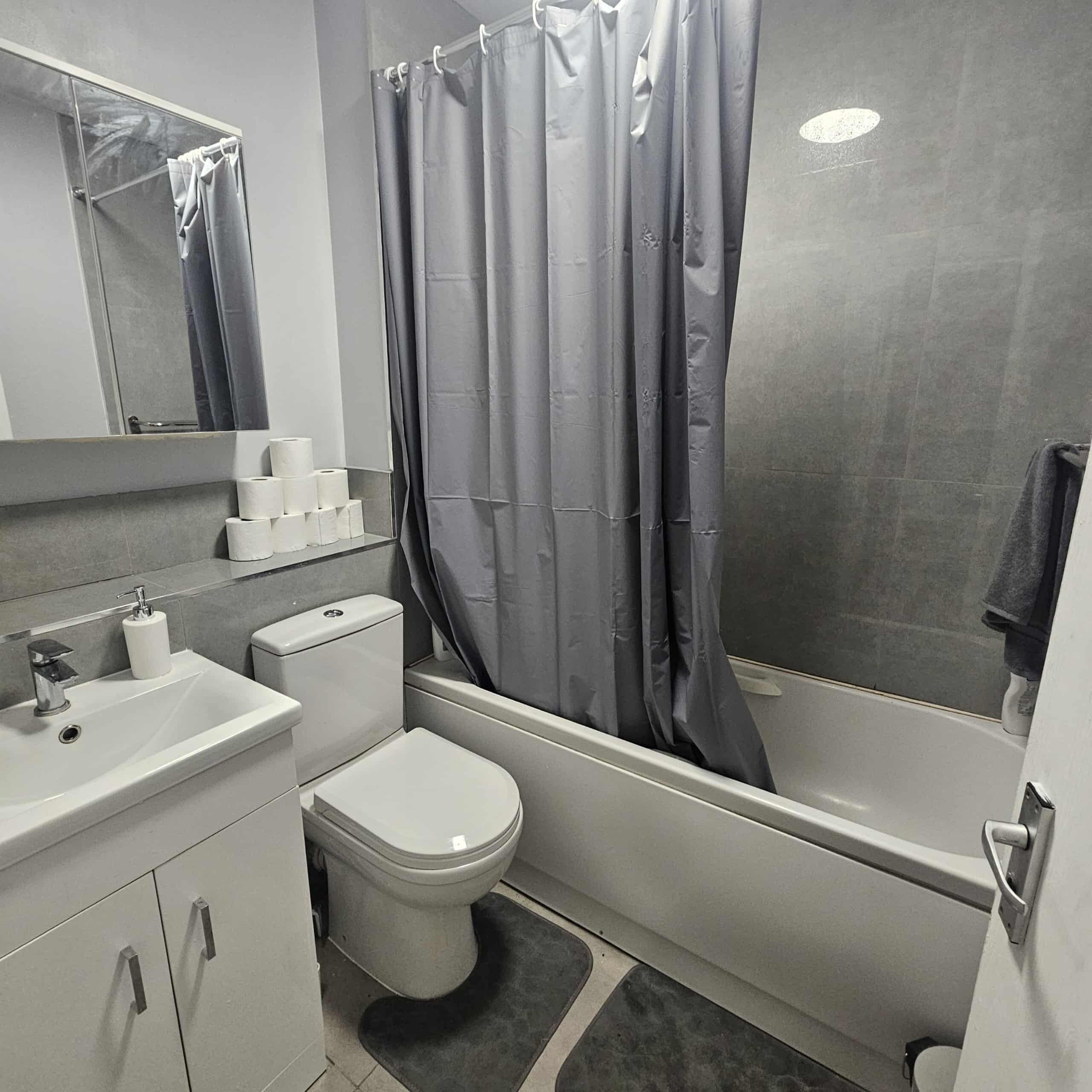 Ein Badezimmer mit Badewanne, Toilette, Waschbecken und Spiegel.