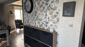 A modern living room with a wooden bench, a clock, and a wall-mounted cabinet. - Le Clos de Candimalo (Epinal–Gérardmer route) (La Baffe)