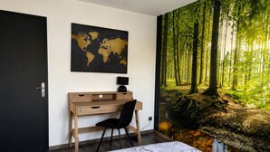 A bedroom with a bed, a desk, a chair, a world map, and a forest mural. - Le Clos de Candimalo (Epinal–Gérardmer route) (La Baffe)