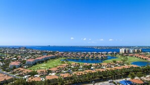 Una zona turística costera con varios edificios, un campo de golf y un puerto deportivo.