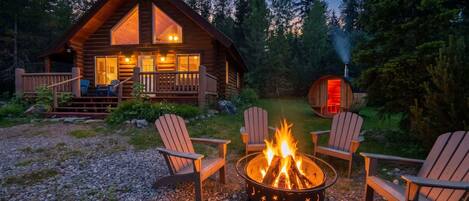 A log cabin with a fire pit and outdoor seating.