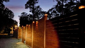 A wooden fence with evenly spaced lights along its length. - Mountain Views ,Sunsets, Jacuzzi spa , Kayak to waterfalls,5 mins to Beaver lake (Eureka Springs)
