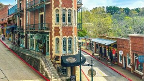 A historic building with a corner entrance, a balcony, and a street view. - Mountain Views ,Sunsets, Jacuzzi spa , Kayak to waterfalls,5 mins to Beaver lake (Eureka Springs)