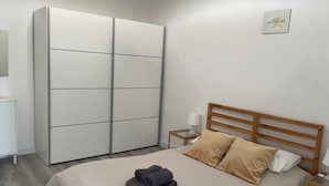 A bedroom with a bed, a wardrobe, a bedside table, and a wall-mounted picture. - Cozy apartment with fantastic views of Las Vistas Beach (Arona)